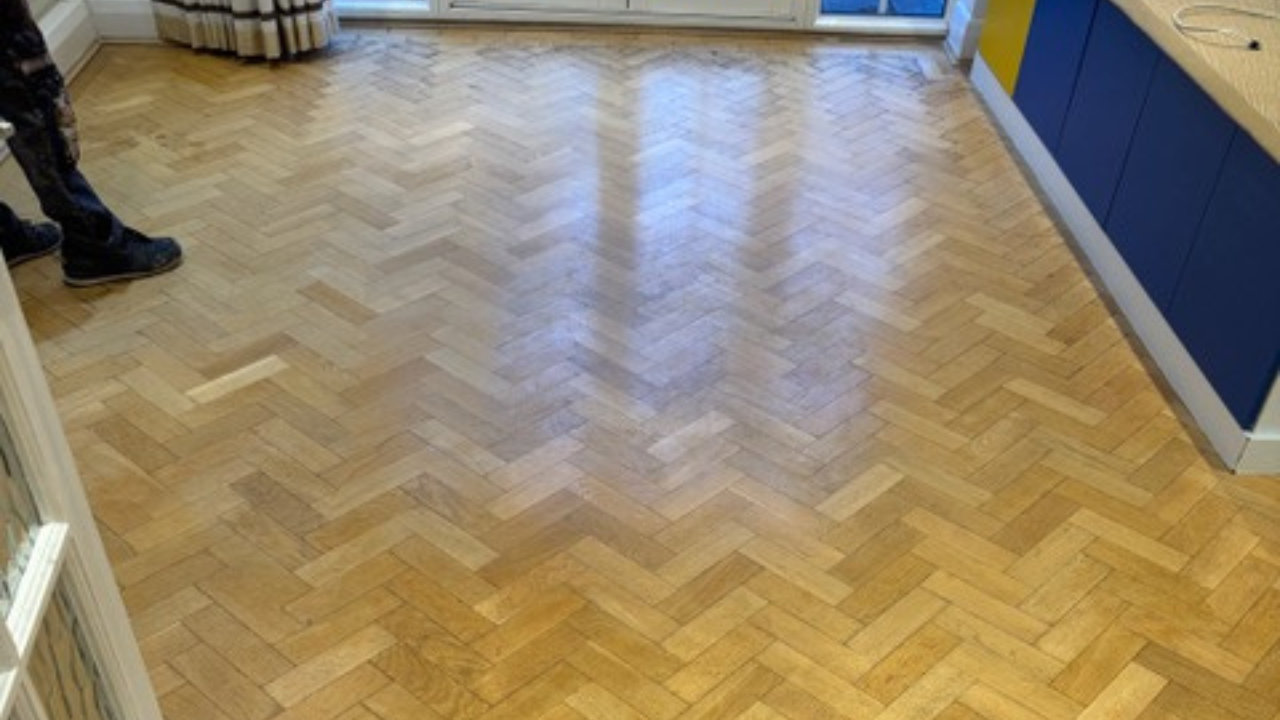 Parquet Floor Sanding in Hackney on a light oak herringbone parquet floor in a kitchen–dining room, showing an even, freshly restored surface.